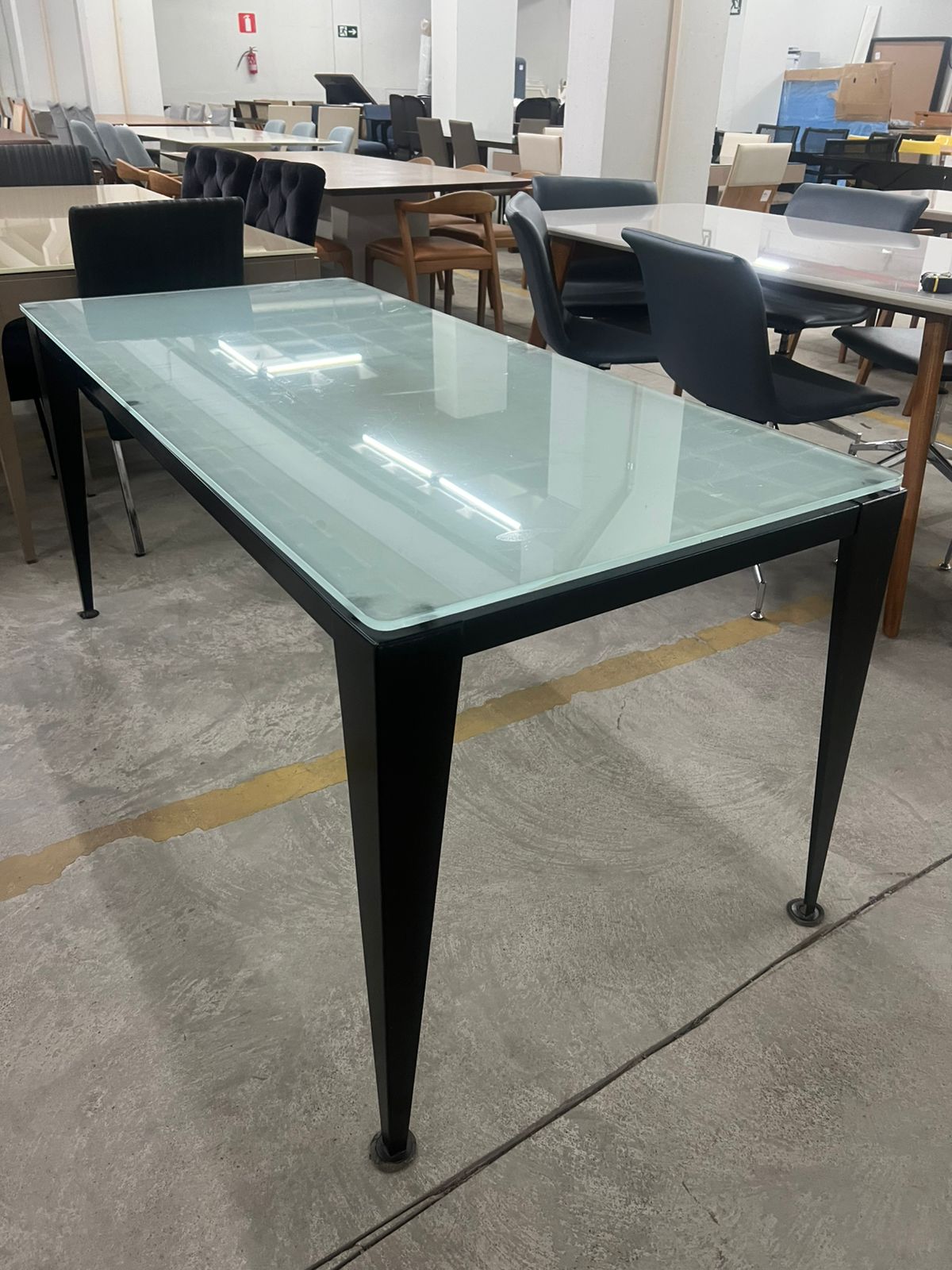 Mesa de escritório com base de ferro e tampo de vidro