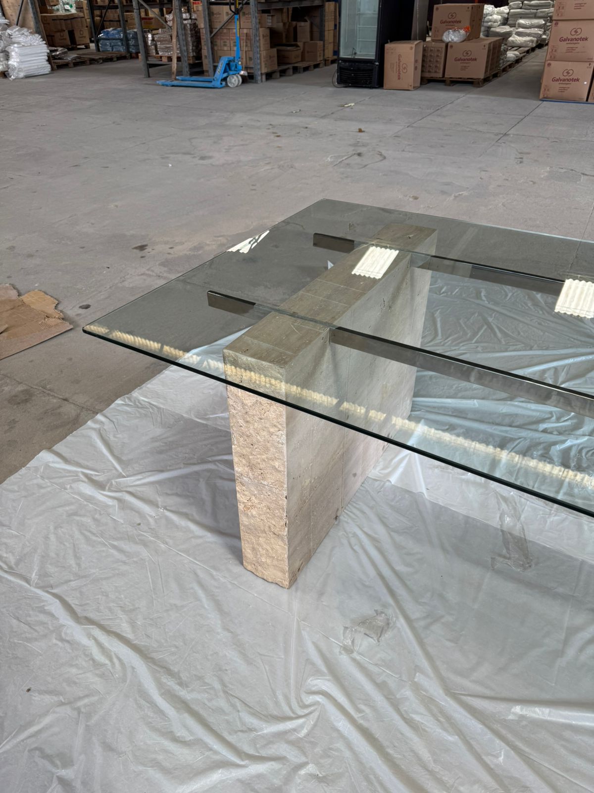 Mesa com tampo em vidro incolor de 10mm temperado com haste inox e os pés em travertino romano