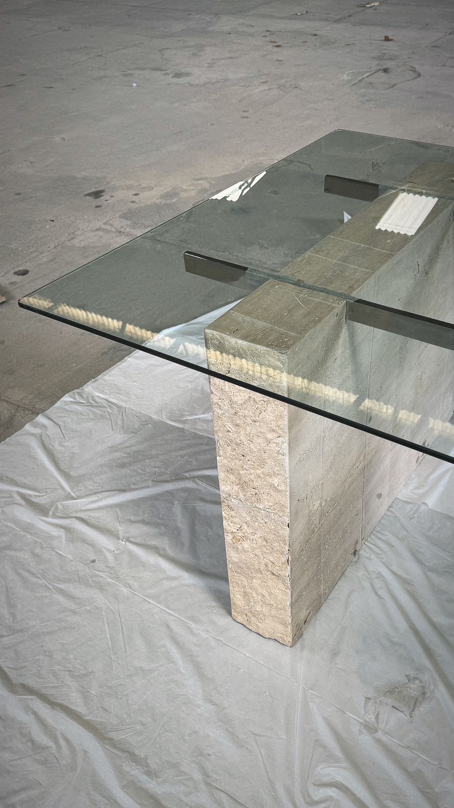 Mesa com tampo em vidro incolor de 10mm temperado com haste inox e os pés em travertino romano