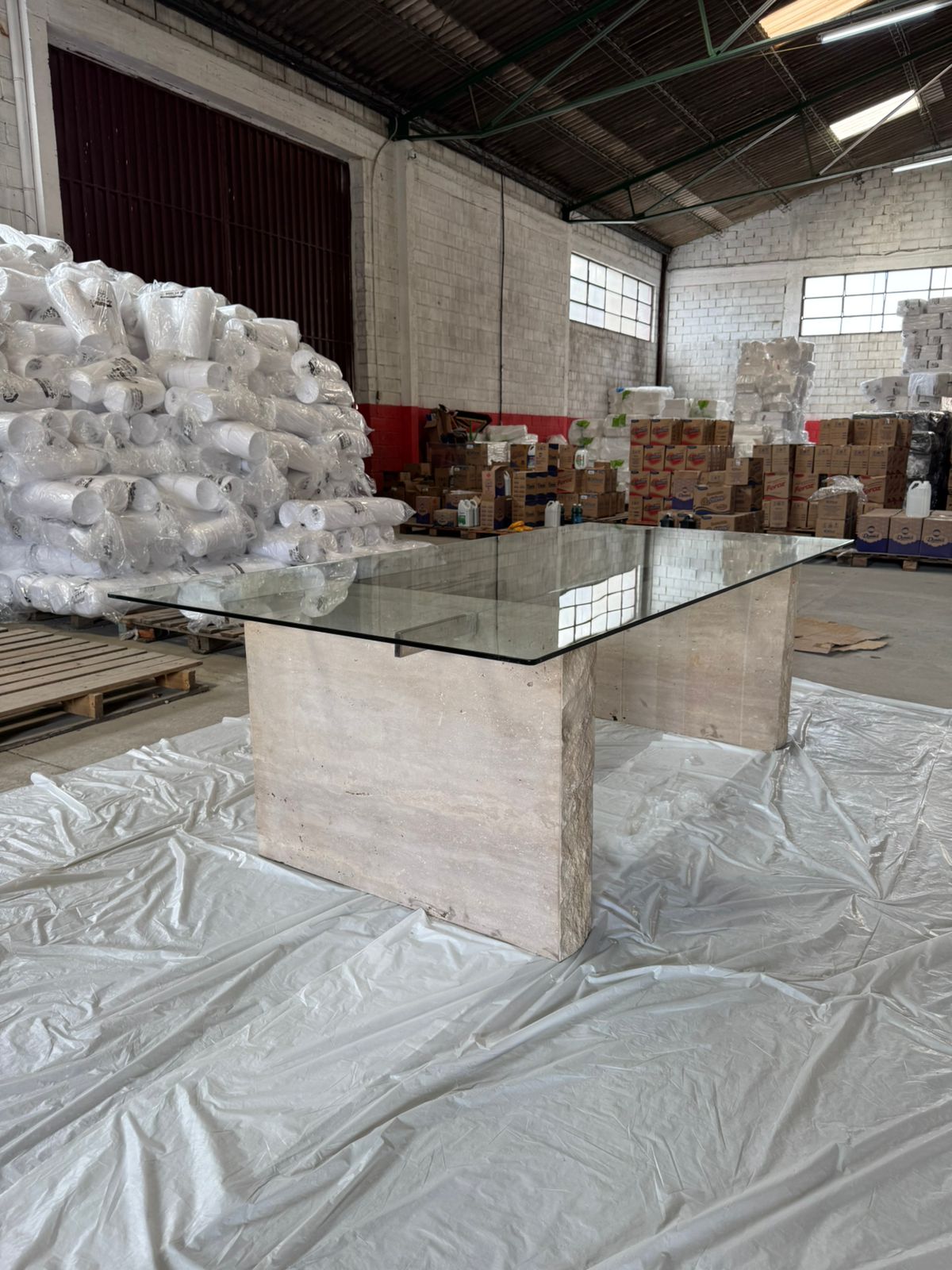 Mesa com tampo em vidro incolor de 10mm temperado com haste inox e os pés em travertino romano
