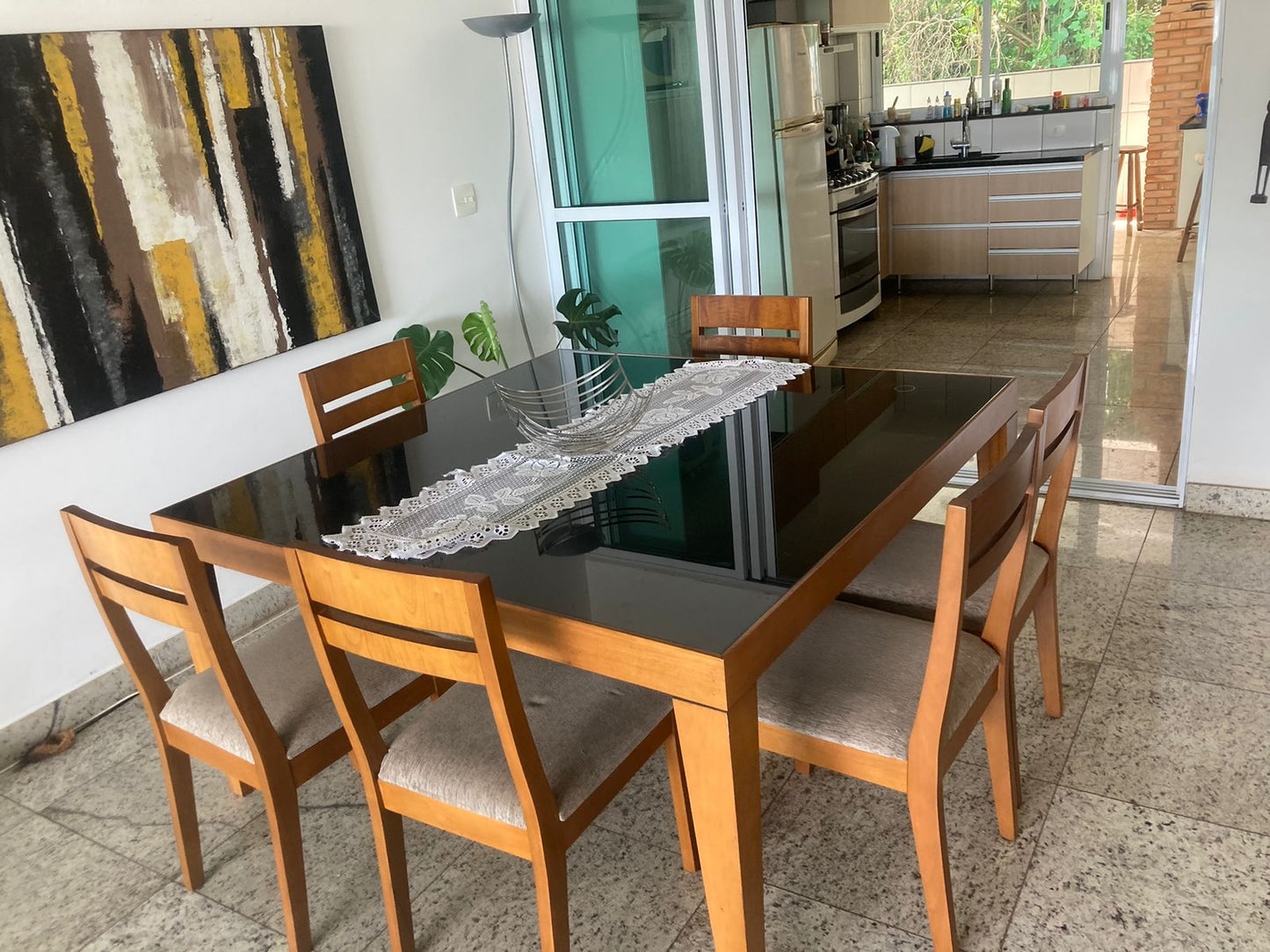 Mesa de jantar de madeira com tampo de vidro laqueado
